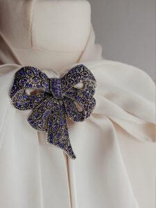 Elegancka broszka kokarda w stylu vintage, ozdobiona cyrkoniami – idealna do płaszcza, marynarki lub sukienki